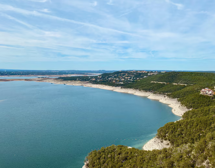 Aerial view of Lake Travis shoreline with homes and Hill Country terrain near Lakeway, Texas